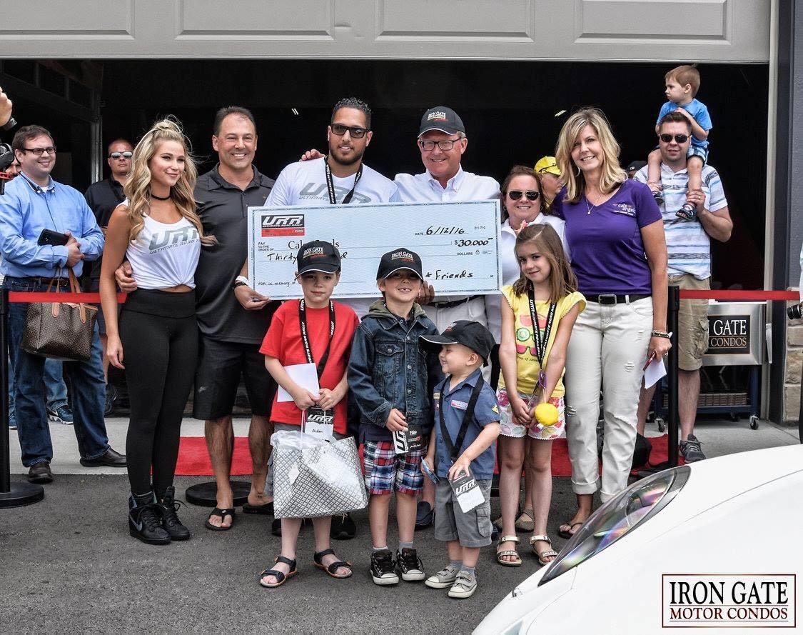 Omar & Iron Gate Motor Condos founder Tom Burgess present the Cal's Angels with a check for $30,000