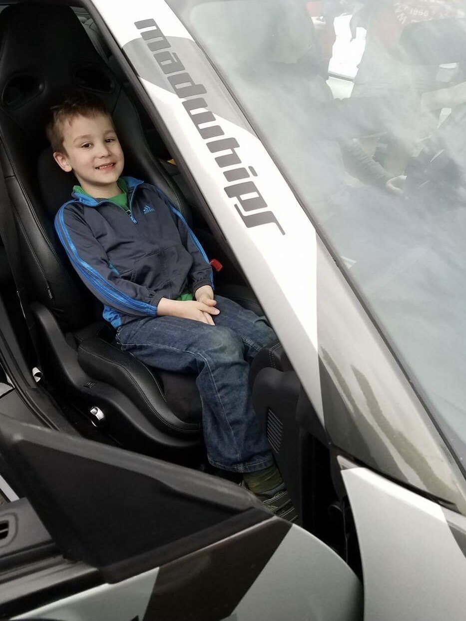 A young GoldRush Rally fan sits in Tim Hayes Alpha 7 Nissan GT-R